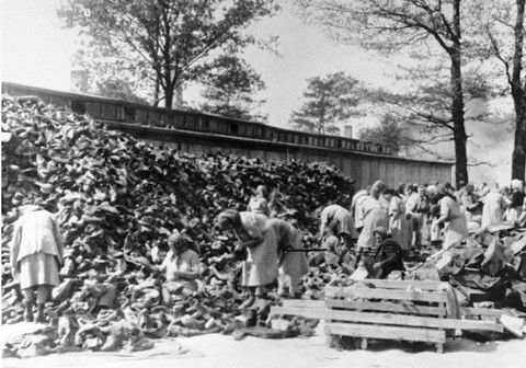 Auschwitz women inmates sort through a huge pile of shoes from the transport of Hungarian Jews
